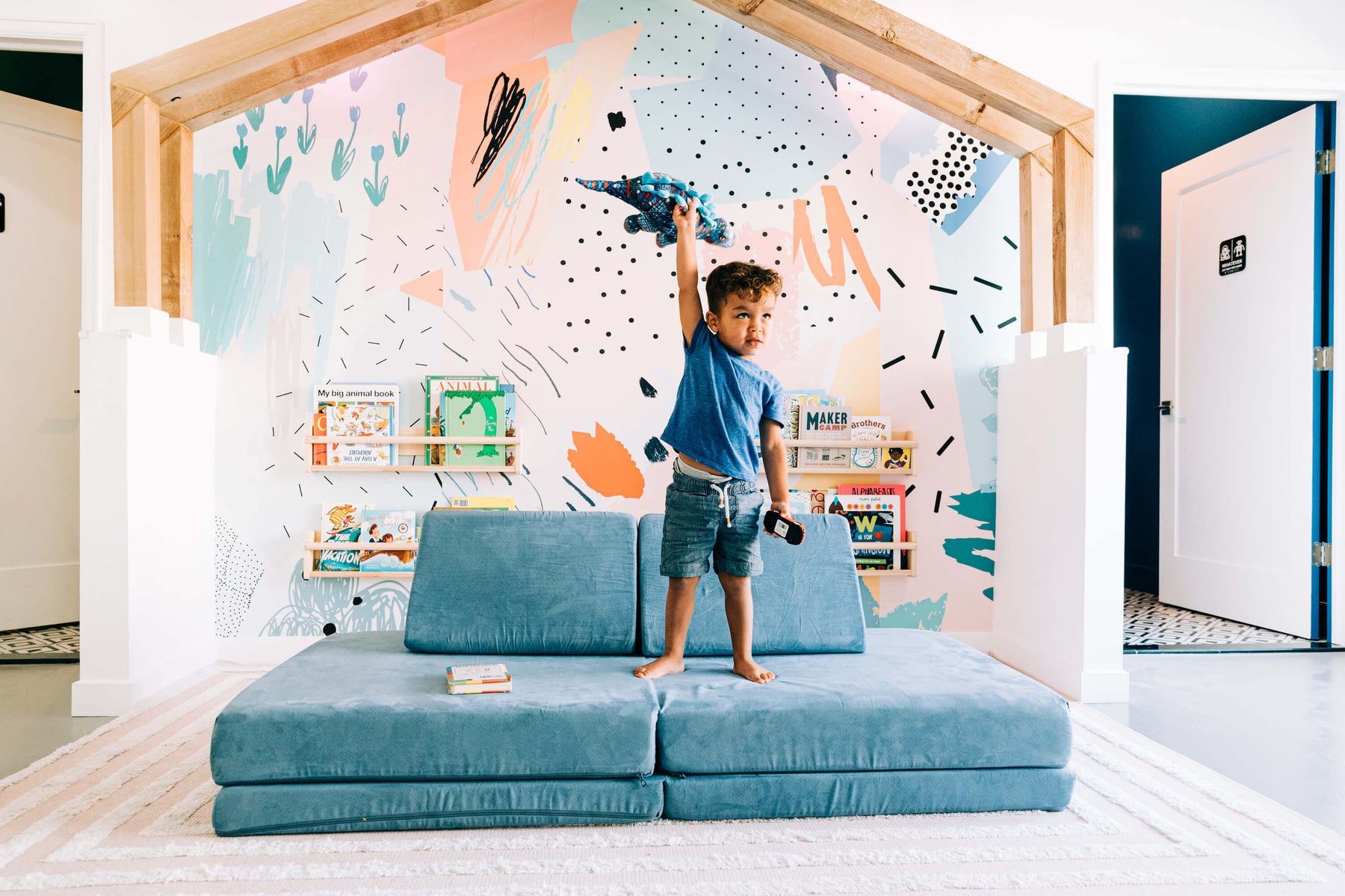 toddler playing inside with a stuffed animal 