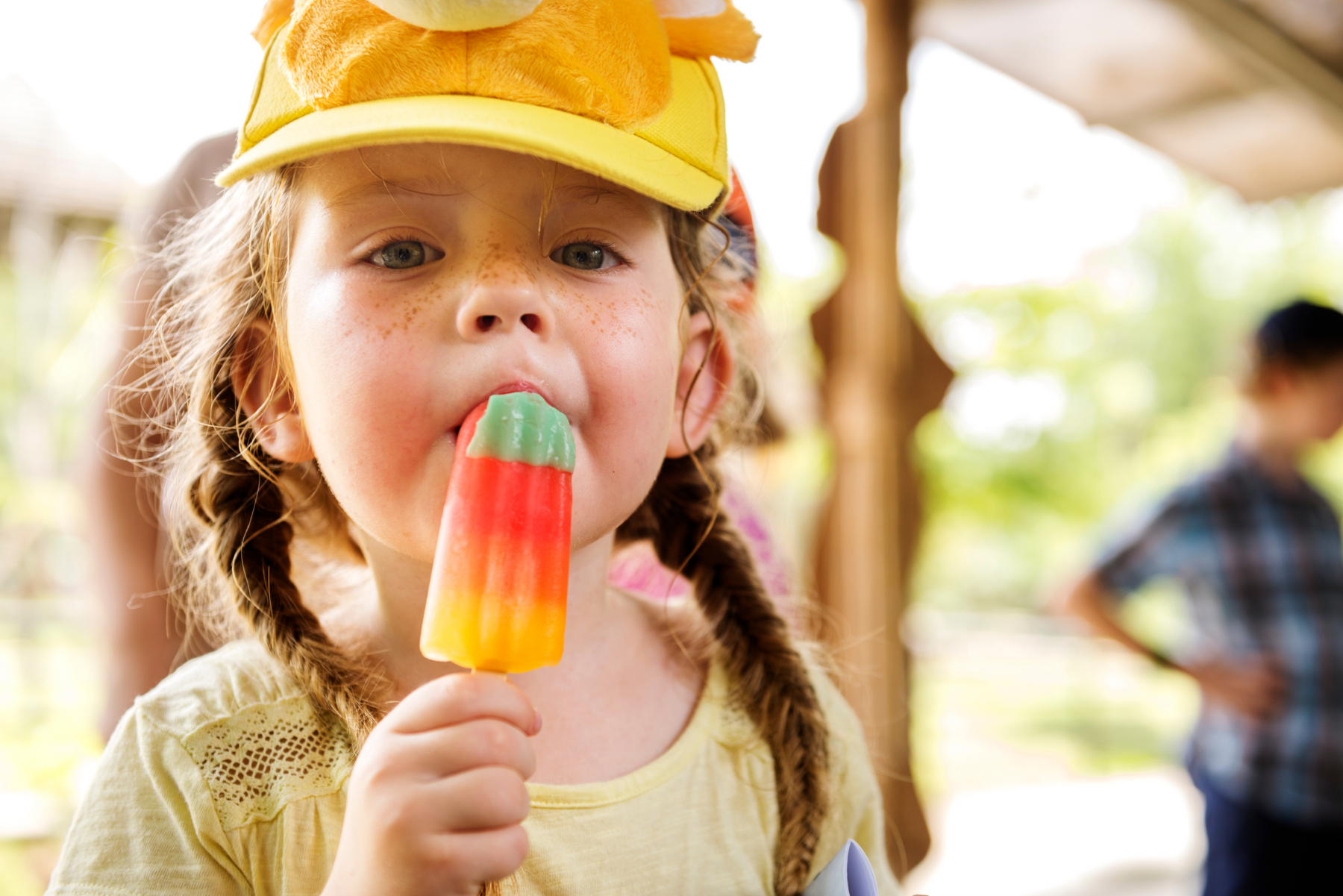 a little girl licking a popsicle 