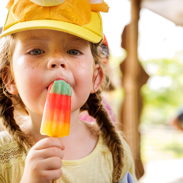 a little girl licking a popsicle 