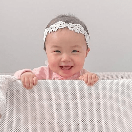 smiling baby in a bassinet 