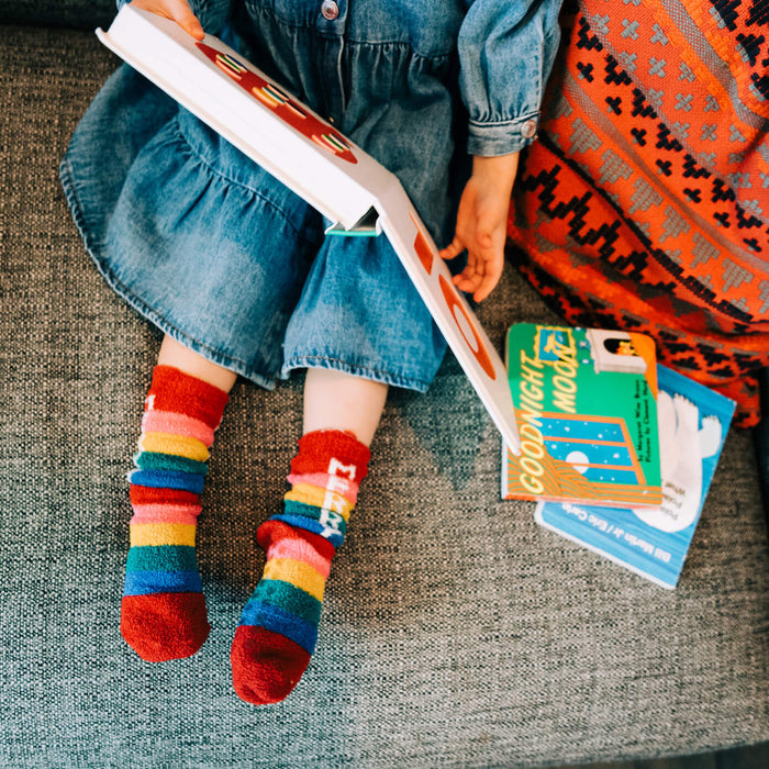 little girl reading a book on the couch in christmas socks