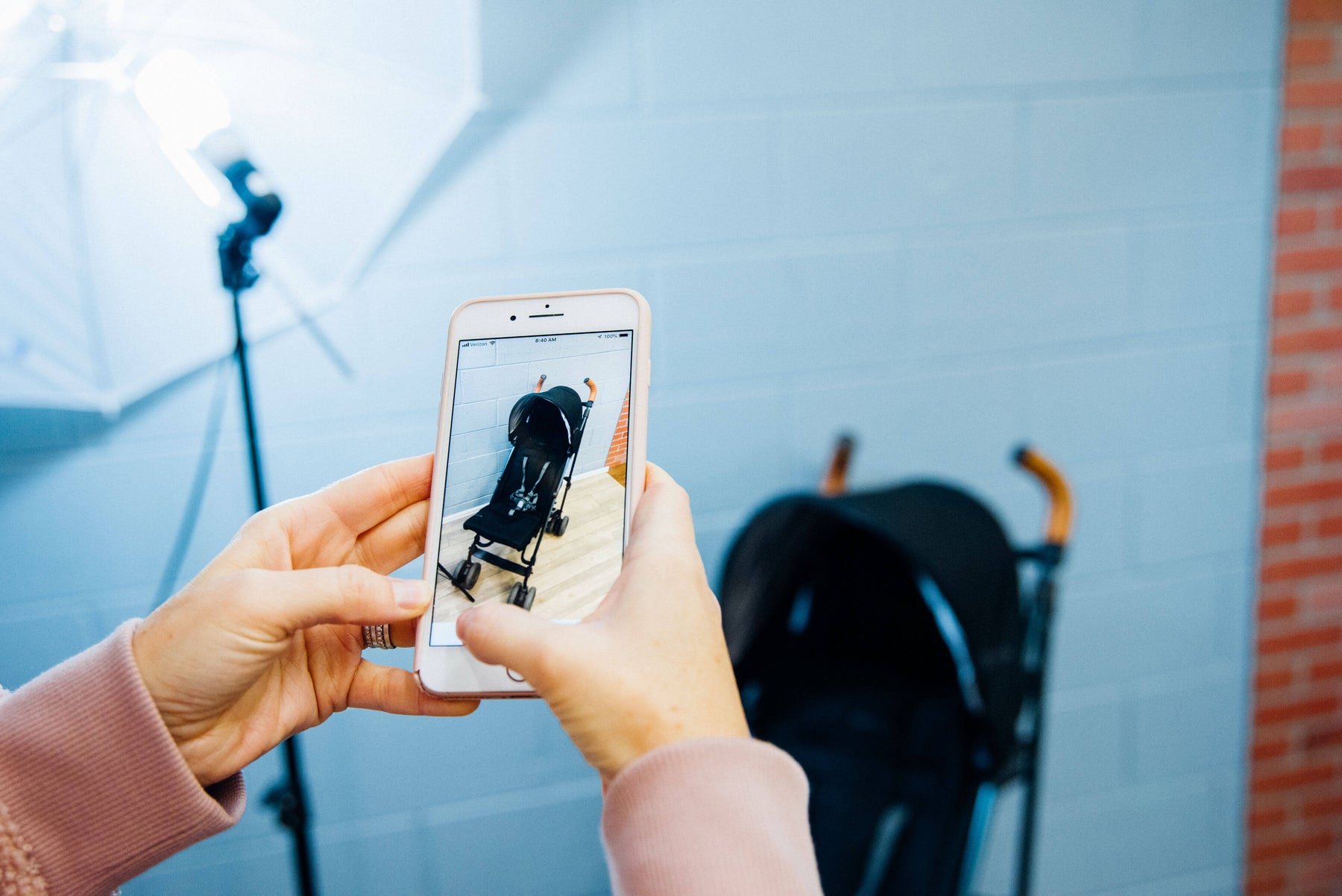 GBG employee taking a photo of a stroller to list on their website