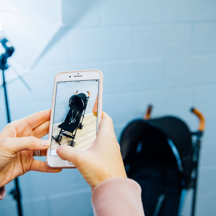 GBG employee taking a photo of a stroller to list on their website