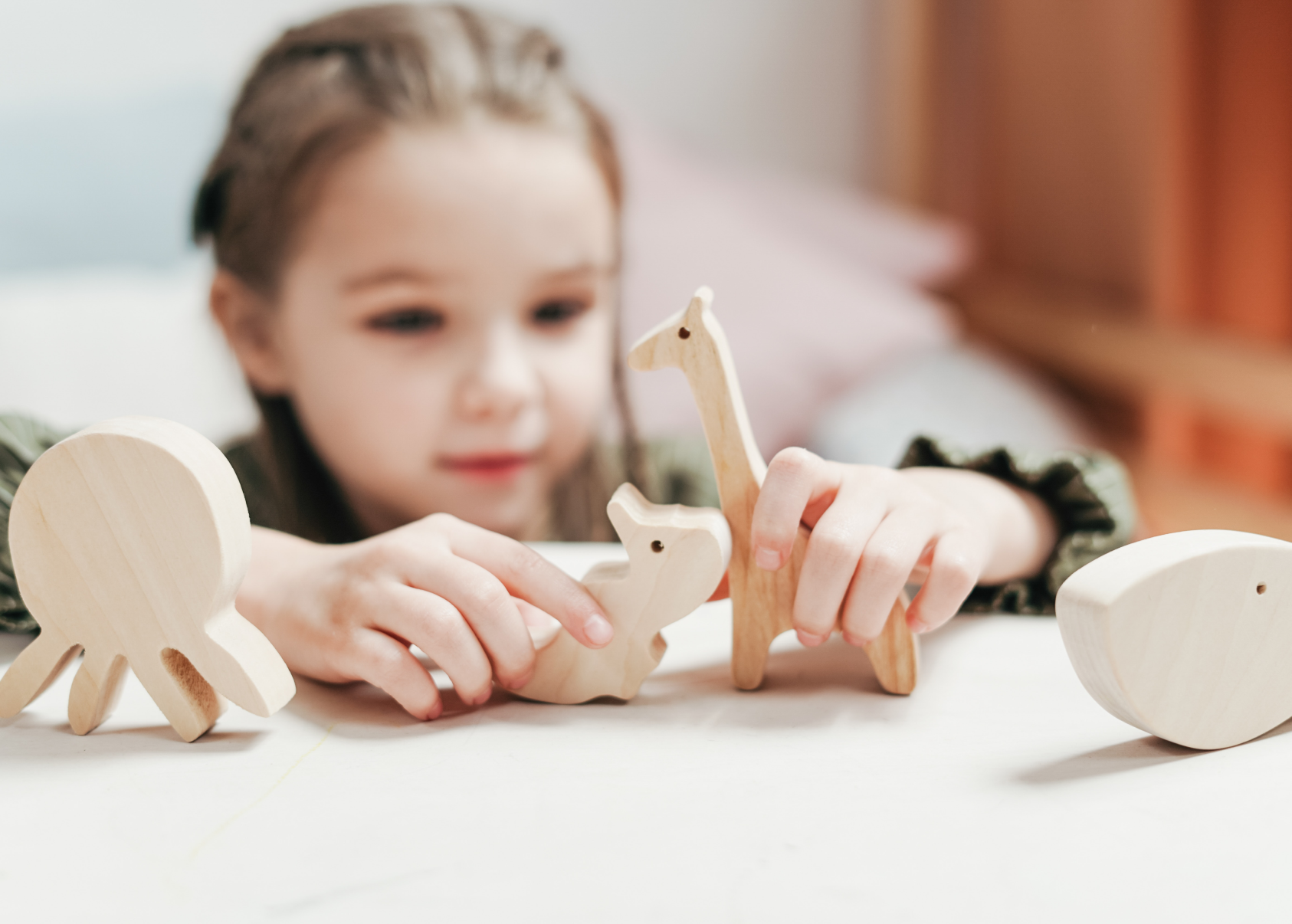 little girl playing with wooden sustainable toys 