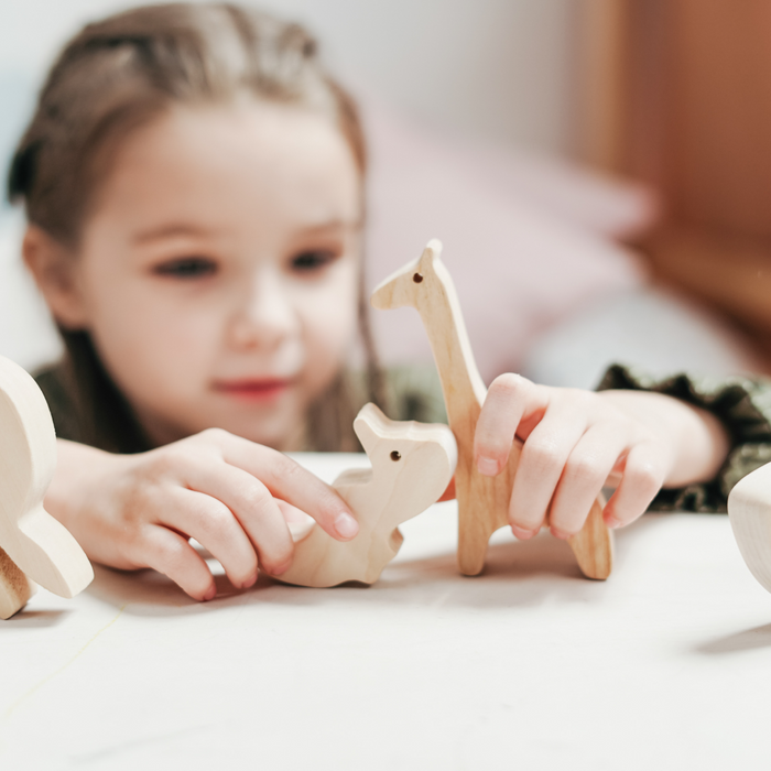 little girl playing with wooden sustainable toys 