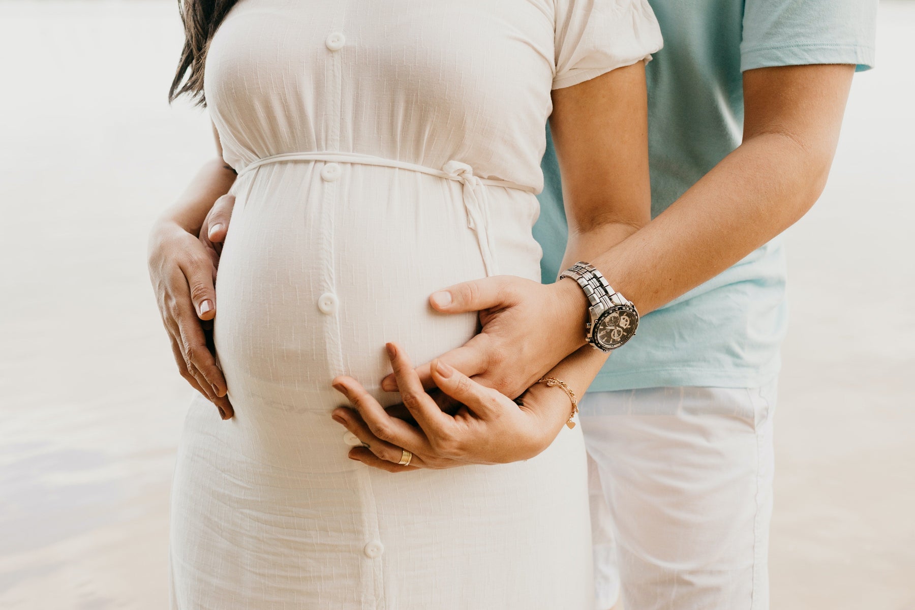 pregnant wife with husband holding belly