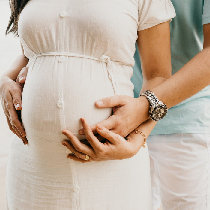 pregnant wife with husband holding belly