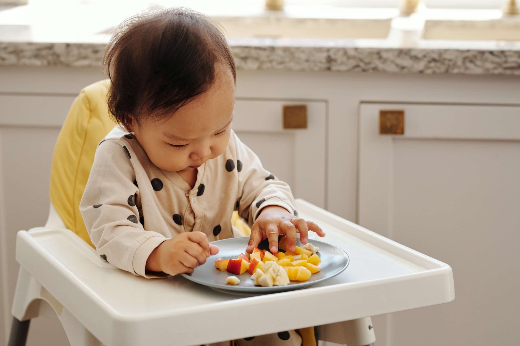 toddler eating in a portable high chair 