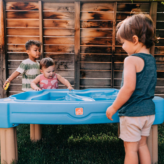 kids playing outside in the summer with a water table