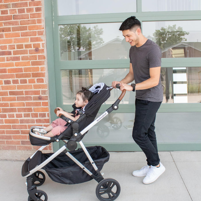 A tall father pushing his daughter in the UPPAbaby Vista 