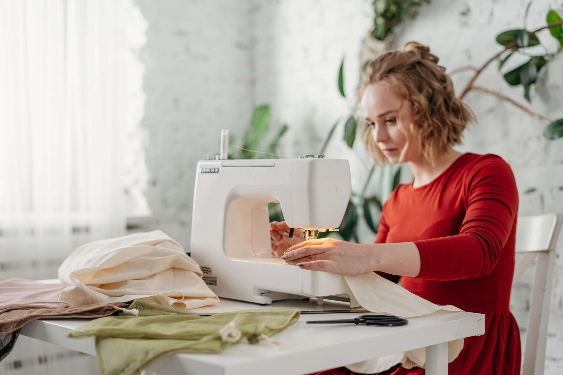 Woman sewing old clothes to upcycle them 