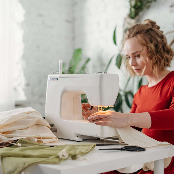 Woman sewing old clothes to upcycle them 