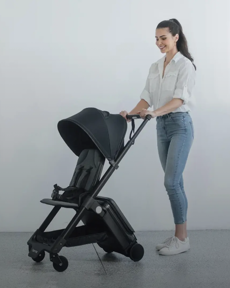 A woman in a white shirt and blue jeans pushes a  TernX Stroller