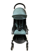 Teal stroller in a warehouse setting with cardboard boxes in the background