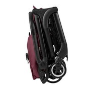 Folded baby stroller with red seat on a white background