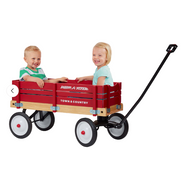 Two children sitting in a red Radio Flyer wagon on a white background